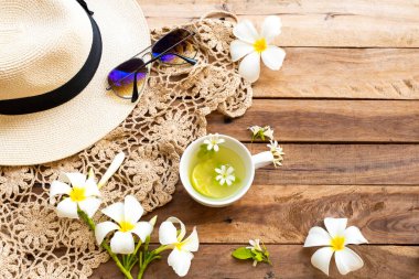 Bitkisel içecekler limonata, örgü ipliği, şapka ve beyaz çiçekler yasemin, hayat tarzı kadının frangipani rahatlama yaz sezonu düzenleme düz arka plan ahşap üzerine yatıyordu