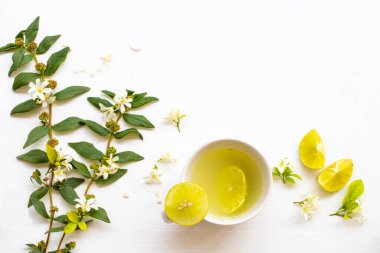 Limon dilimli öksürük için limonata, yasemin çiçekleri rahatlama düzenleme düz zemin üzerinde yatar ahşap beyaz