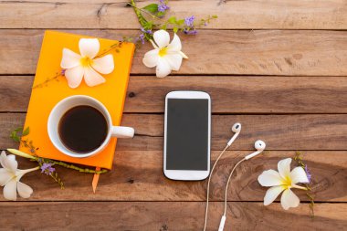 defter günlüğü, cep telefonu ve sıcak kahve espresso beyaz çiçekli iş hayatı için frangipani düzenleme düz arka plan ahşap üzerinde yatıyordu 