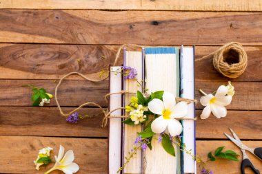 sözlük kitabı, günlük demeti halat ve makas, çiçekler frangipani, yasemin, mor çiçek düzenleme düz arka plan ahşap üzerinde yatıyordu