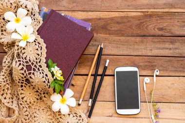 defter, cep telefonu, örgü ipliği ve beyaz çiçekler Frangipani yaşam tarzı gevşeme yaz düzenleme düz arka plan ahşap üzerinde yatıyordu 