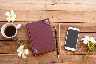defter günlüğü, cep telefonu ve sıcak kahve espresso beyaz çiçekli iş hayatı için frangipani düzenleme düz arka plan ahşap üzerinde yatıyordu 