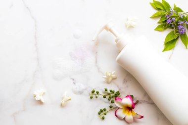 Yaşam tarzının vücut derisi için bitkisel sıvı sabun. Banyoyu ve çiçekleri temizle. Arka planda düz bir şekil oluştur.