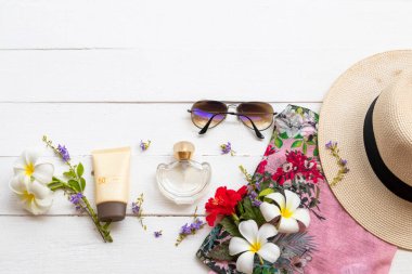 Güneş kremi spf50 cilt sağlığı için parfümlü, pembe elbiseli, güneş gözlüklü kadın rahat yaz düzenleme düz arka plan beyaz ahşap üzerinde yatıyordu 