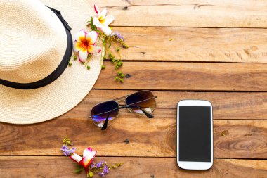 cep telefonu, güneş gözlüğü, şapka ve çiçek frangipani, hayat tarzının mor çiçekleri.