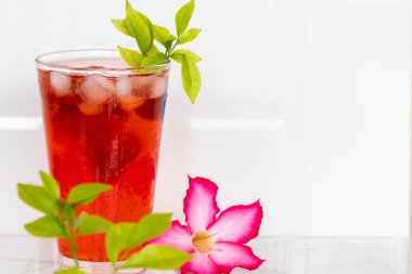 Bitkisel sağlıklı içecekler pembe çiçekli soğuk çilek suyu ve arka planda yaz dekorasyonunda buzlu yaşam tarzı. 