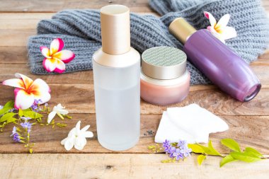 Terapi ilk pamuklu serum tonerleri, göz kremi doğal kozmetik ürünleri cilt için bitkisel sağlık hizmetleri ve yün ören kadın rahatlama düzenlemesi ahşap üzerine yatıyordu.