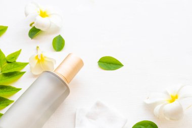 İlk terapi, pamuk doğal kozmetik içeren serum tonerleri cilt için bitkisel sağlık hizmetleri sunar. Kadın yüzü güzelliği ve Frangipani çiçeği, yaprak düzenleme düzleştirici arka plan beyaz üzerine serili. 