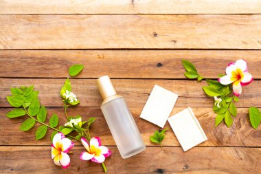 Terapi ile ilk serum tonerleri yeşil çay pamuğu doğal kozmetik ürünleri cilt için bitkisel sağlık hizmetleri yaşam tarzı kadınının ve ahşap üzerinde Frangipani çiçeğinin güzelliği.