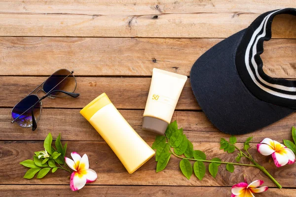 sunscreen spf50 ,body lotion health care for skin with sunglasses ,cap of lifestyle woman in summer arrangement flat lay style on background wooden