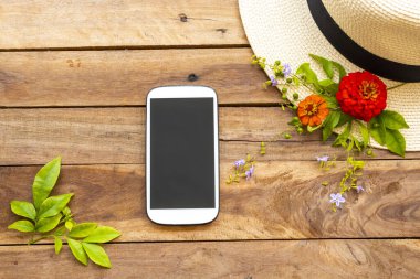 cep telefonu, şapka ve çiçek zinnia hayat tarzı kadının zarifleri rahatla düzenleme tarzı arka plandaki ahşap üzerine serili