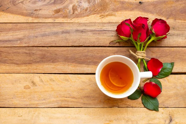 Sağlıklı bitkisel içecekler limon çayı sağlık hizmeti öksürük ağrısı için yaşam tarzı rahatlama kırmızı gül çiçekleri düzenleme düz zemin üzerinde yatar ahşap beyaz
