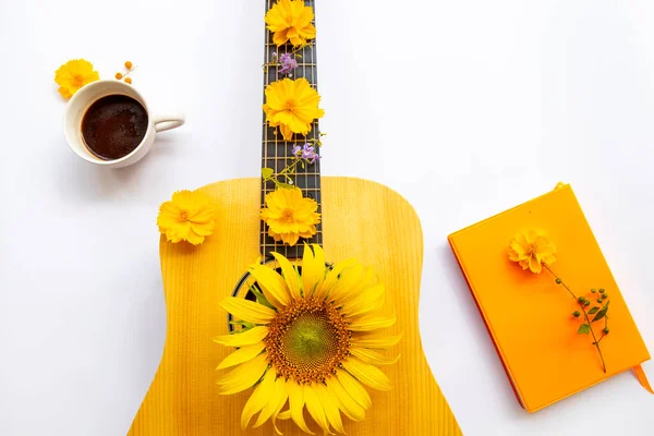 notebook planner ,hot cocoa, guitar and yellow flowers cosmos, sunflowers  of lifestyle arrangement flat lay style on background white