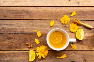 Bitkisel sağlıklı içecekler sıcak bal limonu sağlık hizmeti limon dilimli öksürük ağrısı için, sarı çiçekler yaşam tarzı düzenleme kozmozu düz arka plan ahşap üzerinde yatıyordu