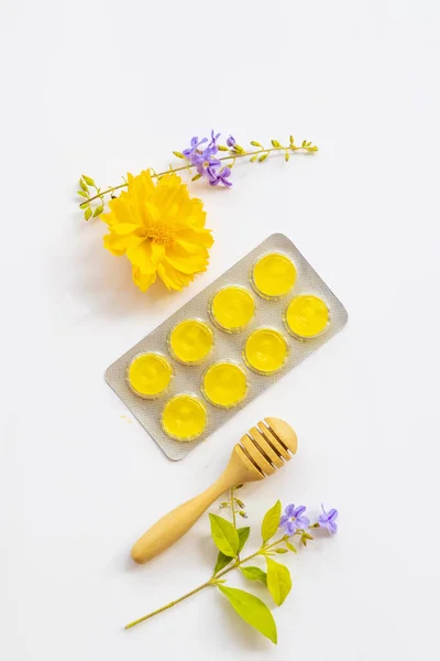 herbal cough sore throat pastille extract vegetable honey lemon for health care with flowers arrangement flat lay style on background white