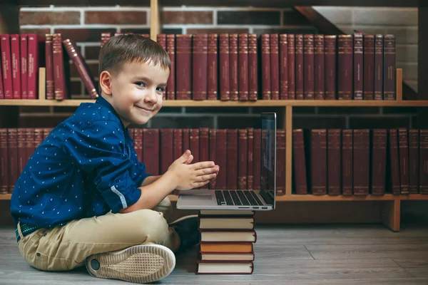 Niño con portátil y libros — Foto de Stock