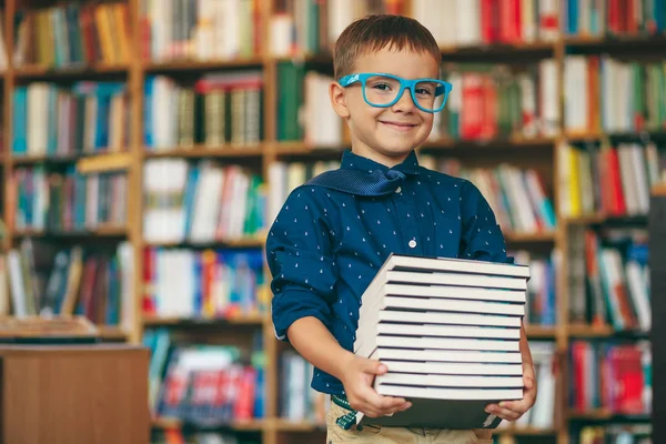 Jongen met bril en stapel boeken — Stockfoto