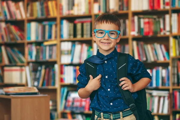 Jongen met rugzak in bibliotheek — Stockfoto