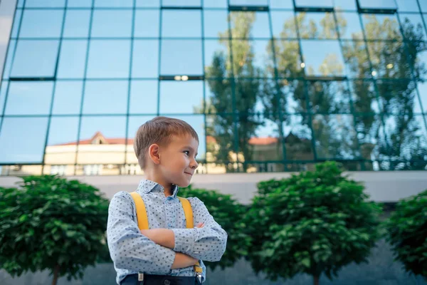 Boy with crossed arms against business center — Stock Photo, Image
