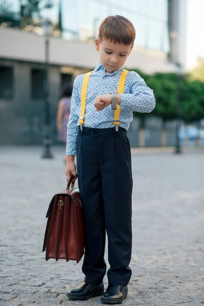 Jongen tijd op zijn zilveren horloge op zijn hand controleren — Stockfoto