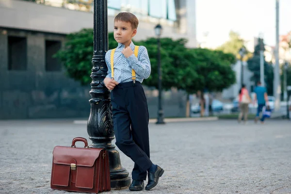 Boy posing on pedestrian street with bown briefcase — Stock Photo, Image