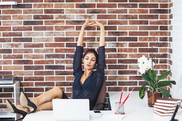 Nyugodt üzleti nő lába az asztalon office kiterjesztése — Stock Fotó