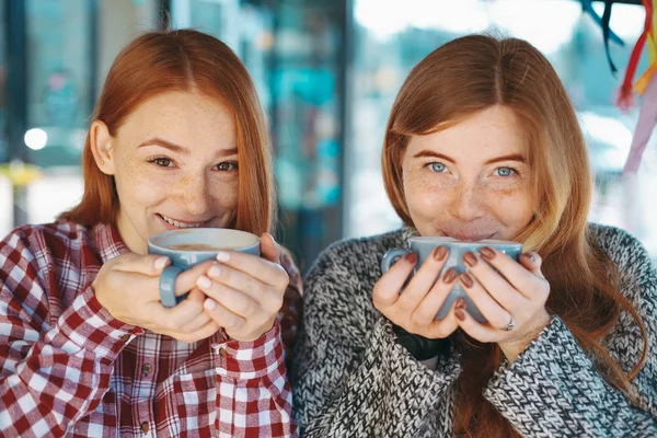 Sonriendo hermosas mujeres jóvenes posando con café —  Fotos de Stock