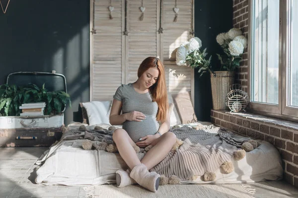 Mulher grávida tocando e olhando para a barriga — Fotografia de Stock
