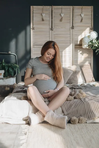 Těhotná žena dotýká a při pohledu na její břicho — Stock fotografie