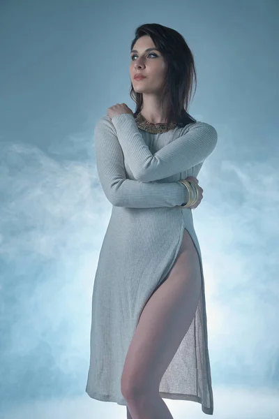 Mulher retrato vestindo um vestido com um corte profundo no backgrou fumegante — Fotografia de Stock