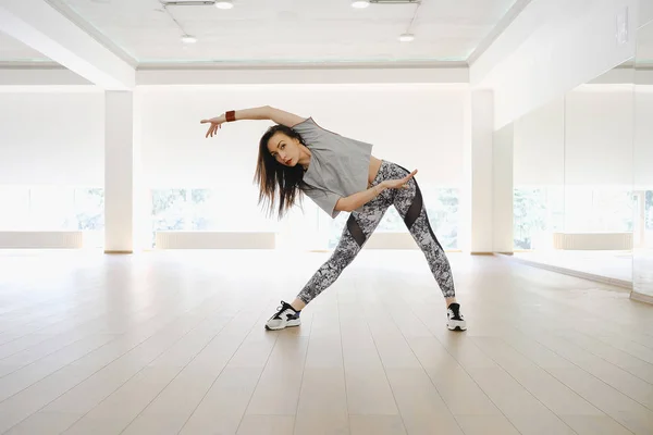 Athletic young girl performing sports and dance alone in a studi