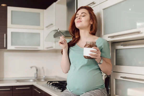 Těhotná žena se těší jíst čokoládu — Stock fotografie