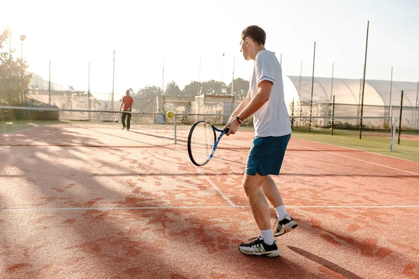 Hombre jugando al tenis en la mañana a la luz del sol — Foto de Stock