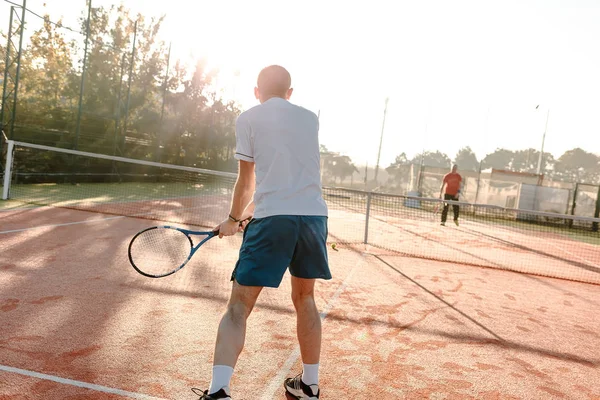 Hombre jugando al tenis en la mañana a la luz del sol — Foto de Stock