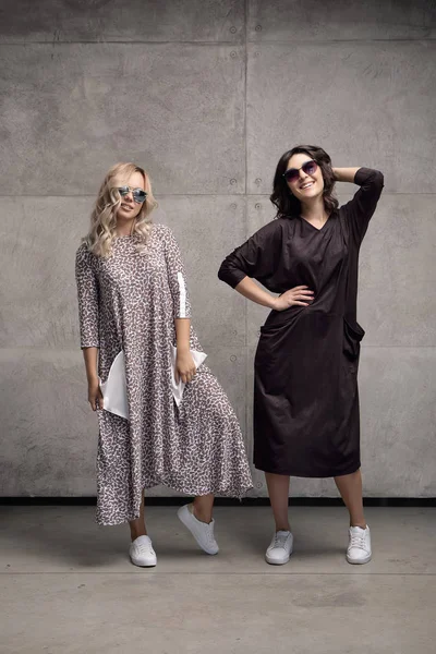 Dvě veselé moderní mladé ženy nosí sluneční brýle — Stock fotografie