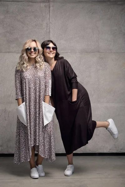 Deux joyeux jeunes femmes branchées portant des lunettes de soleil — Photo