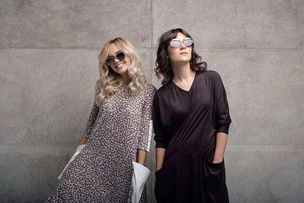 Dos jóvenes alegres y de moda con gafas de sol —  Fotos de Stock