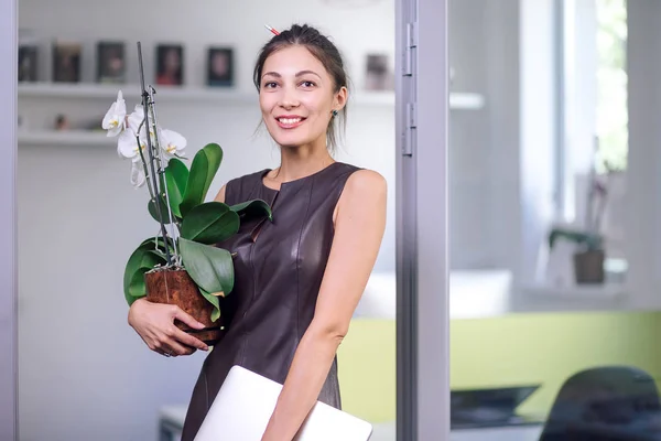 Mujer atractiva en vestido de cuero que se mueve en la nueva oficina — Foto de Stock