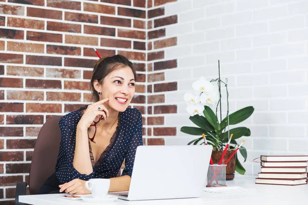 Glimlachende zakenvrouw in gesprek met iemand op kantoor — Stockfoto