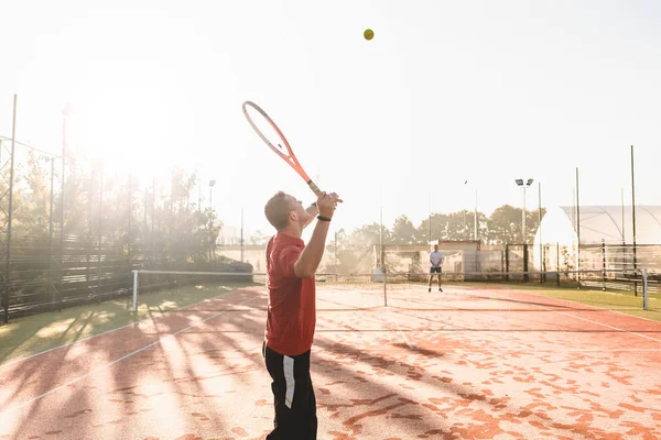 Joven está jugando al tenis en la mañana fresca y soleada — Foto de Stock
