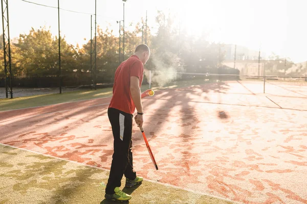 Молодой человек играет в теннис свежим солнечным утром — стоковое фото