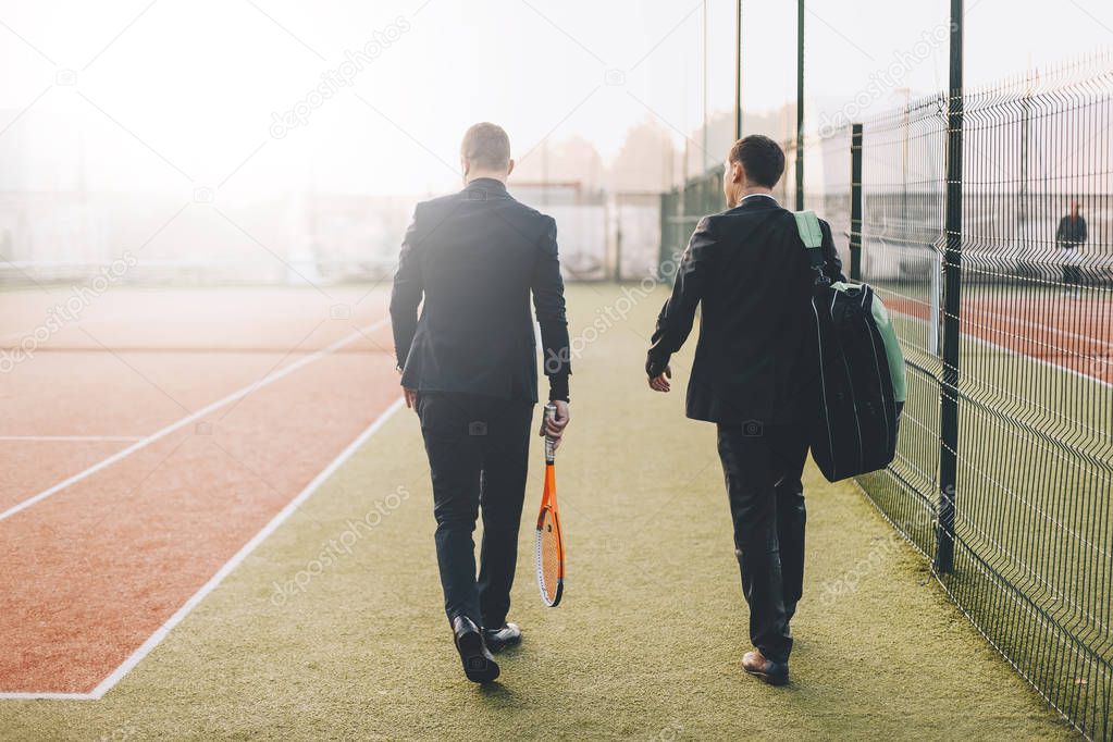 Two businessmen walking and communicating