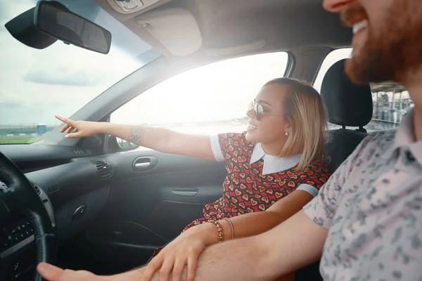 Mulher excitada mostrando algo enquanto sentada no carro — Fotografia de Stock