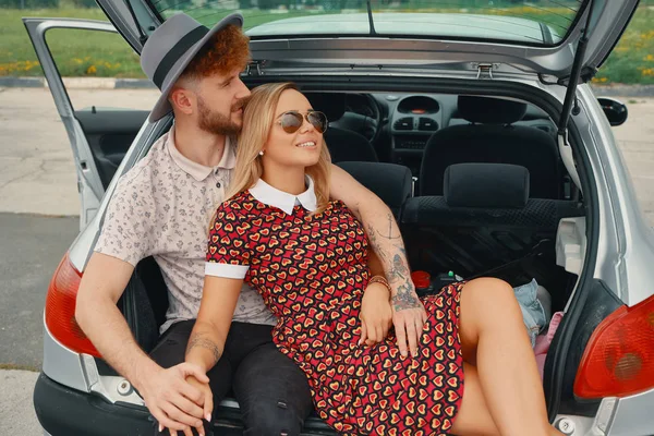 Mutlu çifti beraber araba bagajında otururken iyi eğlenceler — Stok fotoğraf