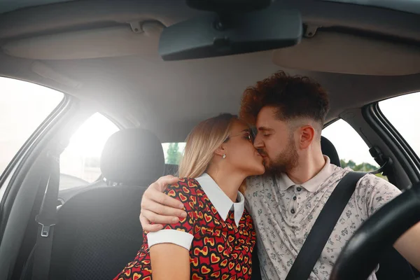 Hermosa pareja joven besándose en el asiento delantero del coche —  Fotos de Stock