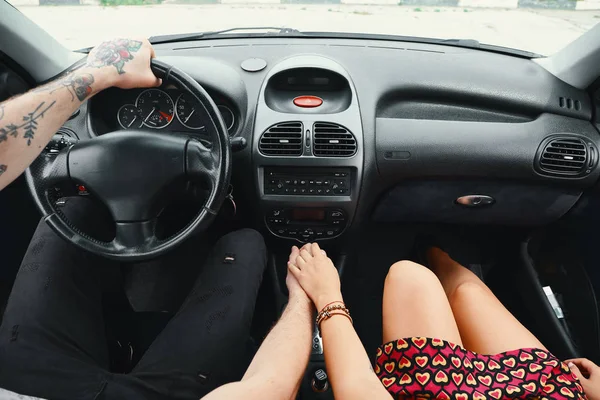 Junges Paar, das mit dem Auto unterwegs ist, hält sich an den Händen und schaut zu — Stockfoto