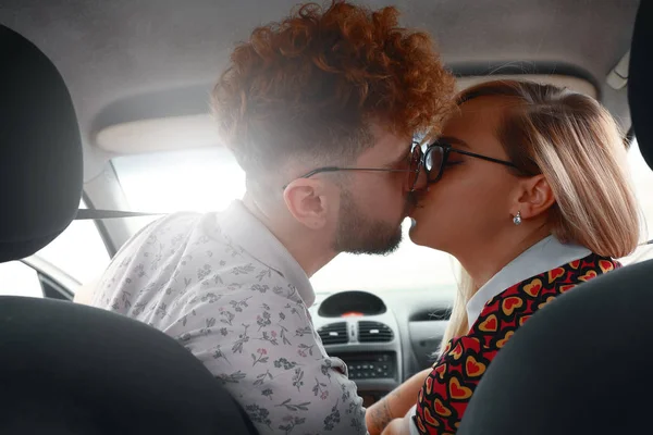 Hermosa pareja joven besándose en el asiento delantero del coche —  Fotos de Stock