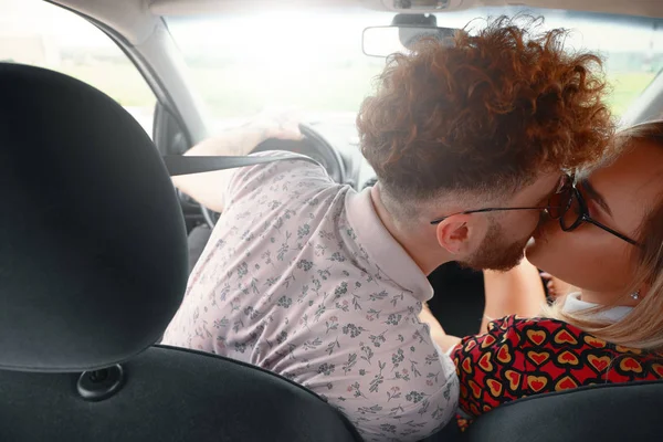 Hermosa pareja joven besándose en el asiento delantero del coche —  Fotos de Stock