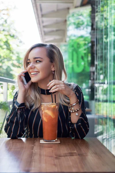 Mulher loira adorável usando smartphone sentado no terraço — Fotografia de Stock