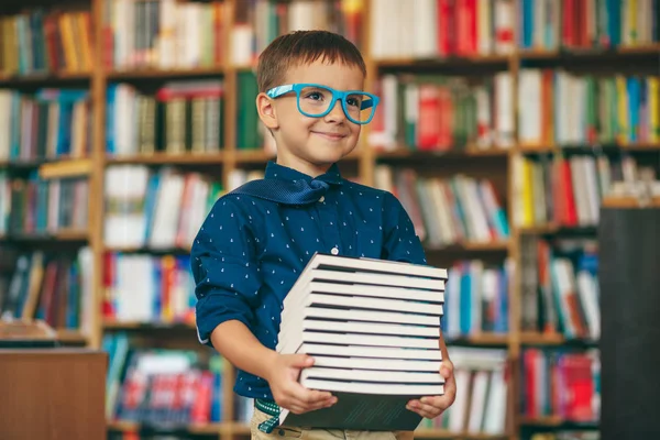 Jongen met bril en stapel boeken — Stockfoto